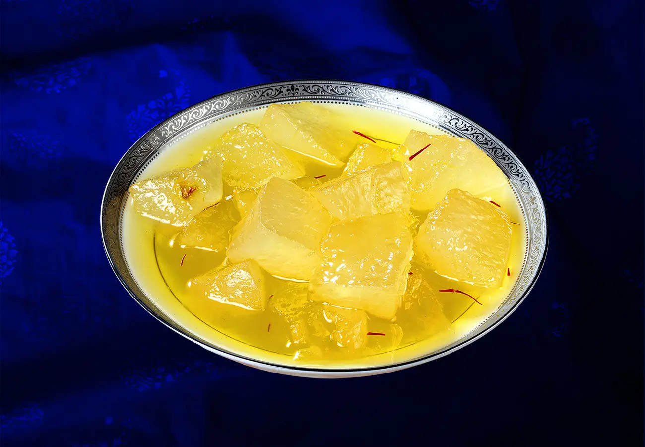 Close-up of Kumhra ka Murabba, showcasing translucent, juicy white pumpkin pieces immersed in a rich, jam-like sweet syrup, exemplifying the rich heritage of Sheherwali cuisine