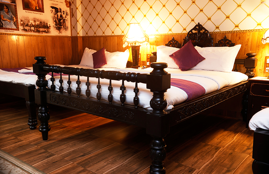 An intricately carved Bengal-style Victorian bed on display at House of Sheherwali, showcasing a fusion of British and Bengali craftsmanship.