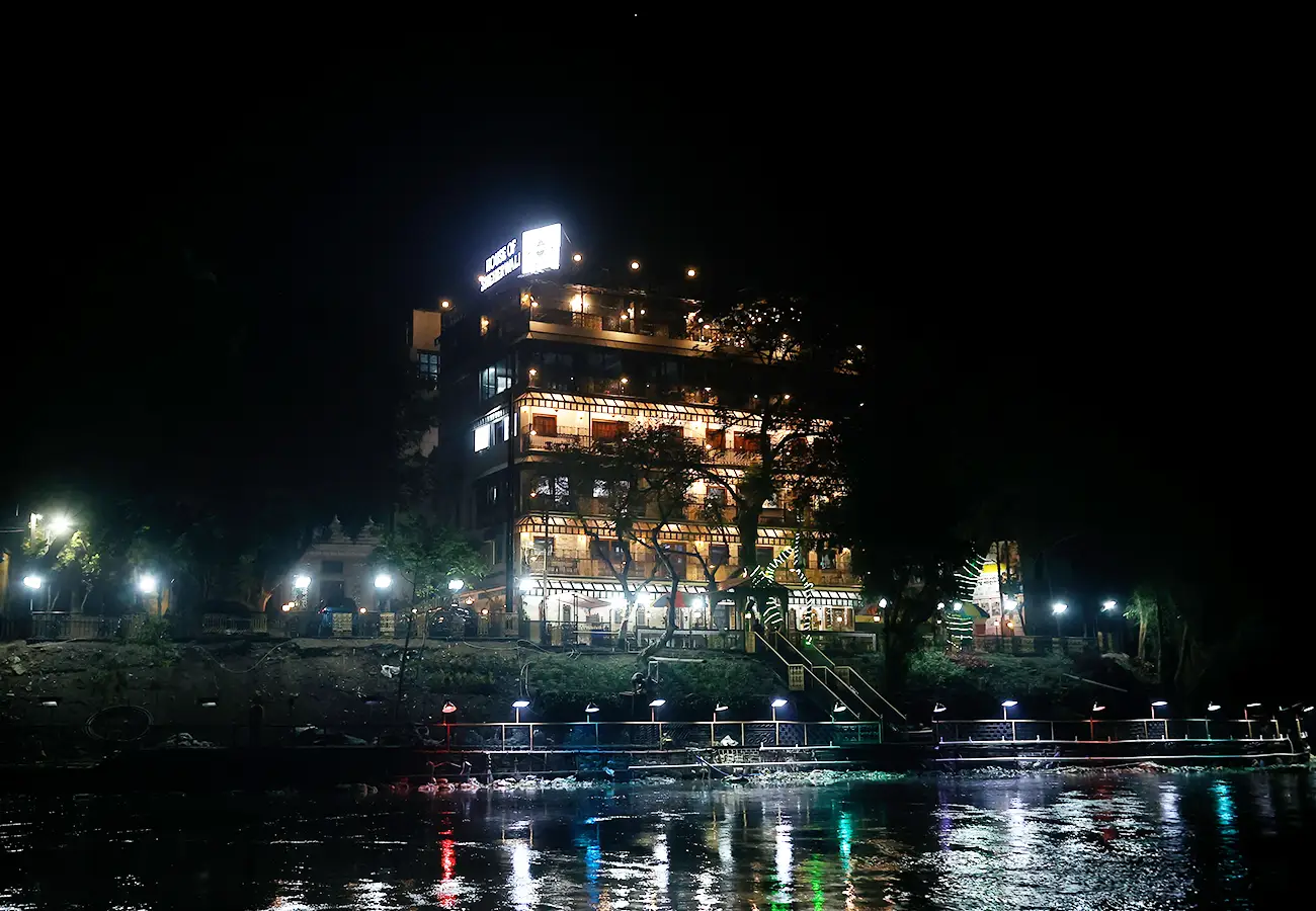 Ganges view of illuminated building from boat at night