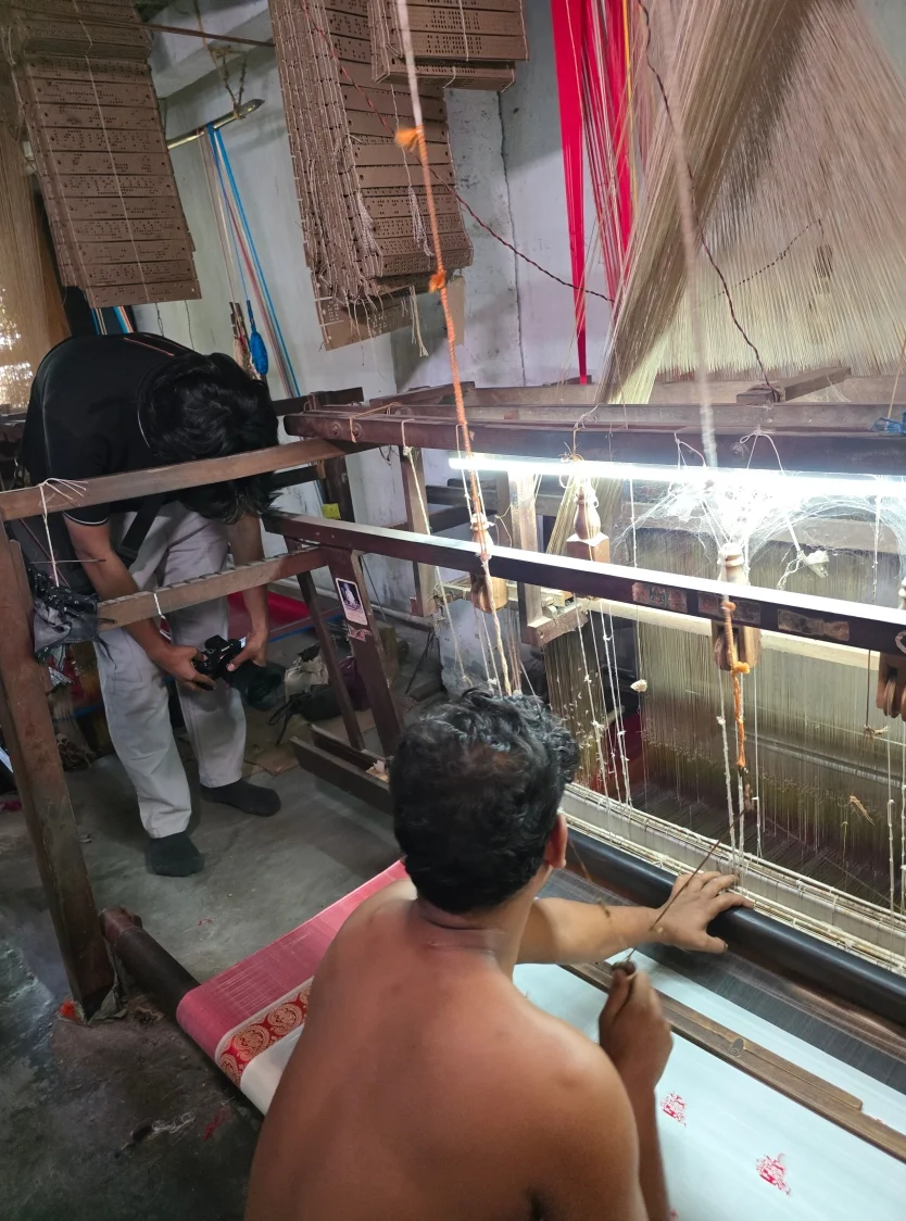 A weaver demonstrates traditional Baluchari silk handloom weaving to visiting students in Murshidabad